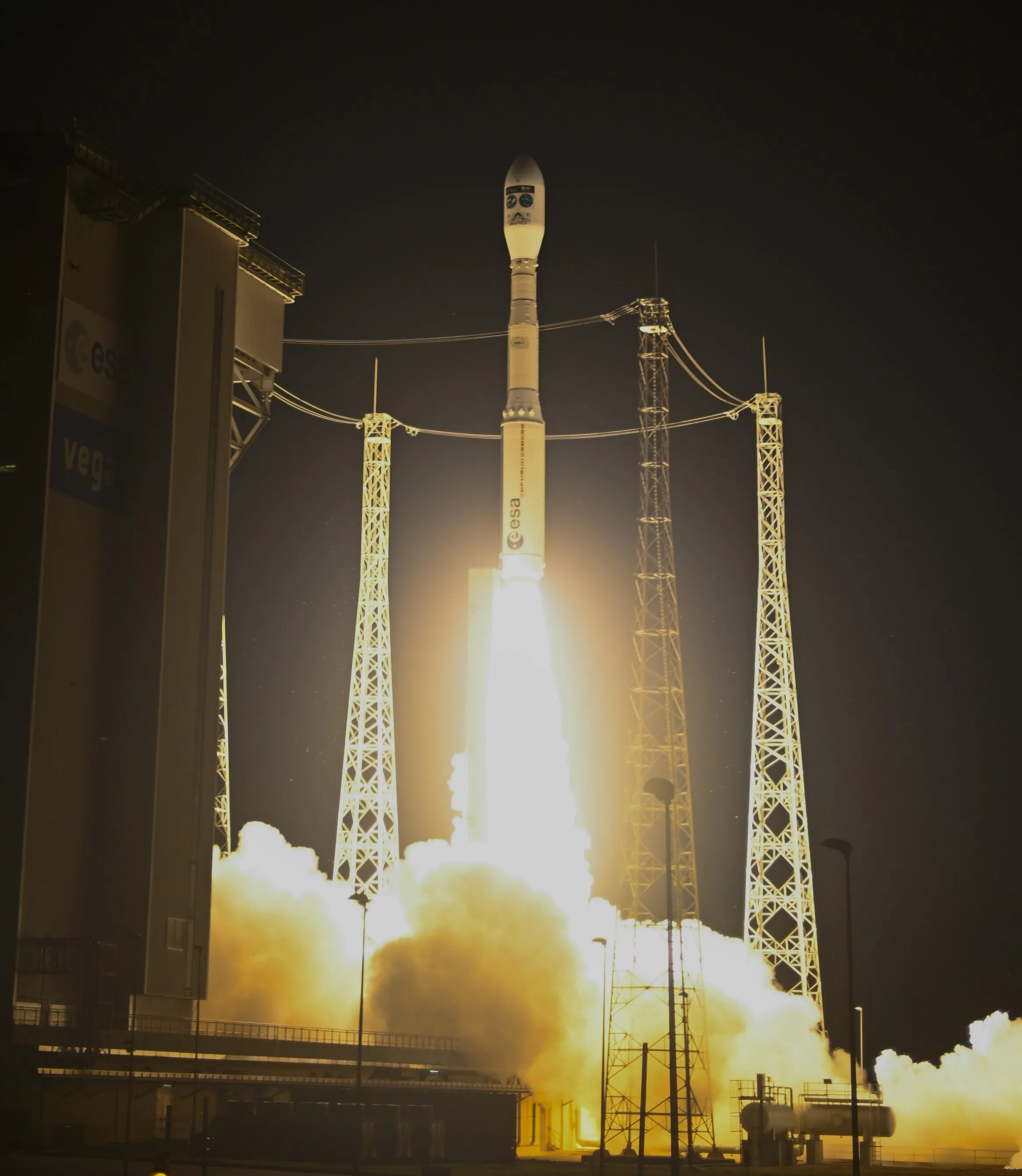 Un cohete Vega-C despega de noche desde el puerto espacial europeo en la Guayana Francesa, con el fuego de los motores iluminando la torre, llevando a bordo FLEX y Sentinel-3C