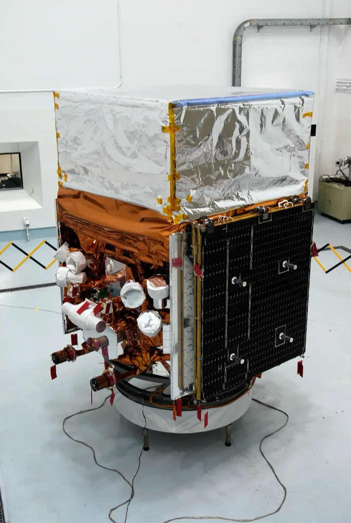 Fermi, still called GLAST, in a clean room in Florida before its launch in 2008: a foil-wrapped box of instruments on a copper-wrapped body, a folded solar panel at its side.