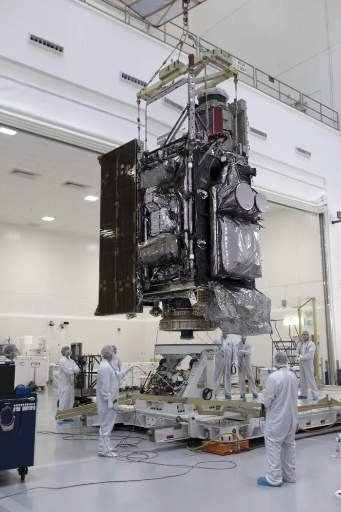The GOES-S weather satellite, later named GOES-17, hanging from a crane as technicians move it to a work stand in a clean room in Titusville, Florida, in December 2017.