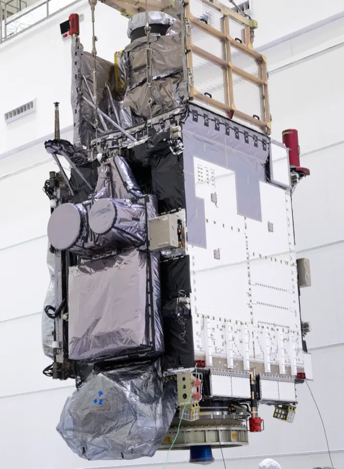 The GOES-U weather satellite, later named GOES-19, hanging from a crane in a clean room near Kennedy Space Center in January 2024.