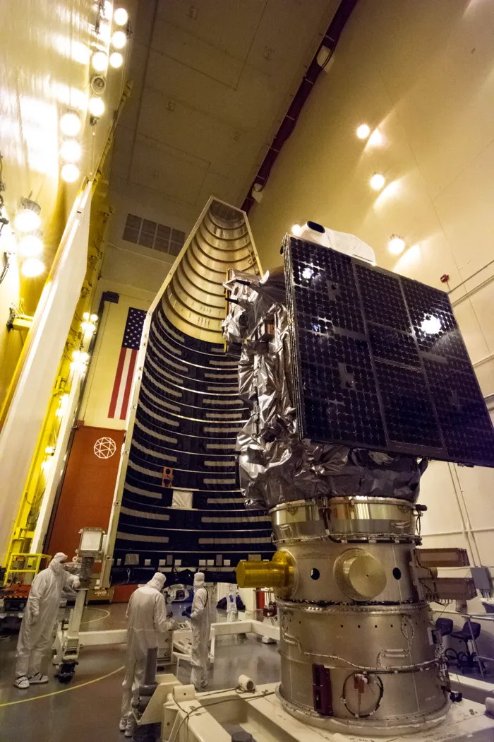 The Landsat 9 spacecraft with its folded solar array, in front of the rocket fairing that will enclose it, at Vandenberg in August 2021.