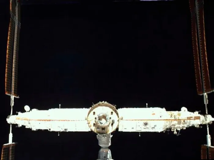 The Tiangong space station seen from behind, with the Mengtian, Tianhe and Wentian modules in a row and a Shenzhou spacecraft docked below.